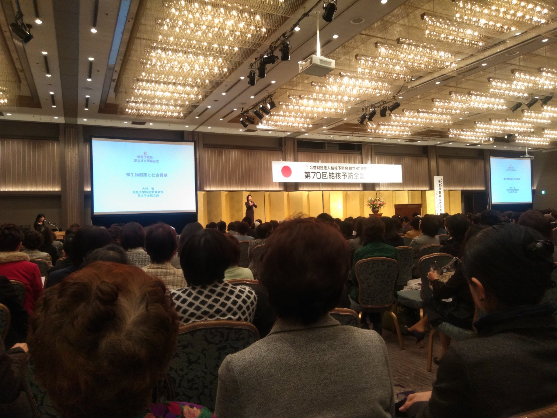 写真です。結核予防全国大会の会場で、数百人の参加者が講演を聞いています。