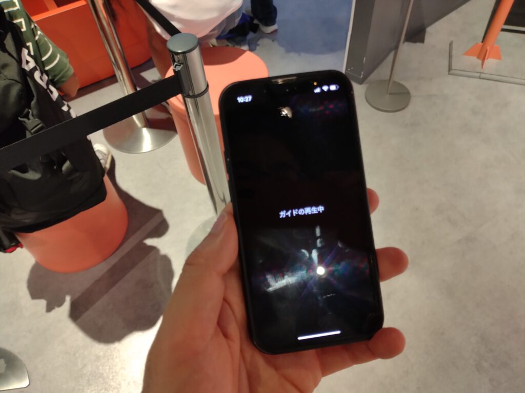 スマホ画面に「ガイドの再生中」と表示されている
