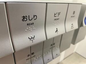 イメージ画像：日本語と英語、イラストと点字で機能を表示しているトイレのボタン