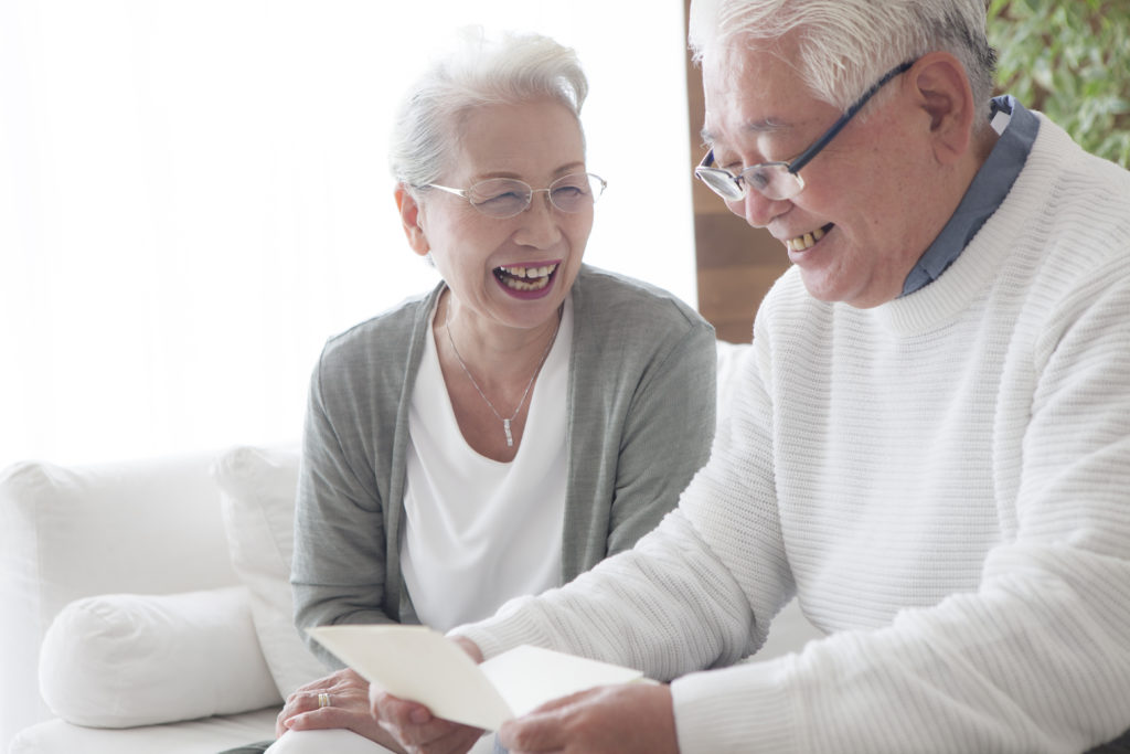 写真：笑顔でパンフレットを読んでいる老夫婦