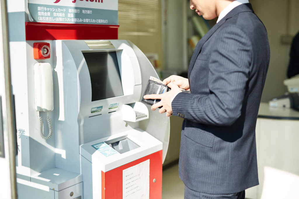イメージ画像：ATMを使うサラリーマン