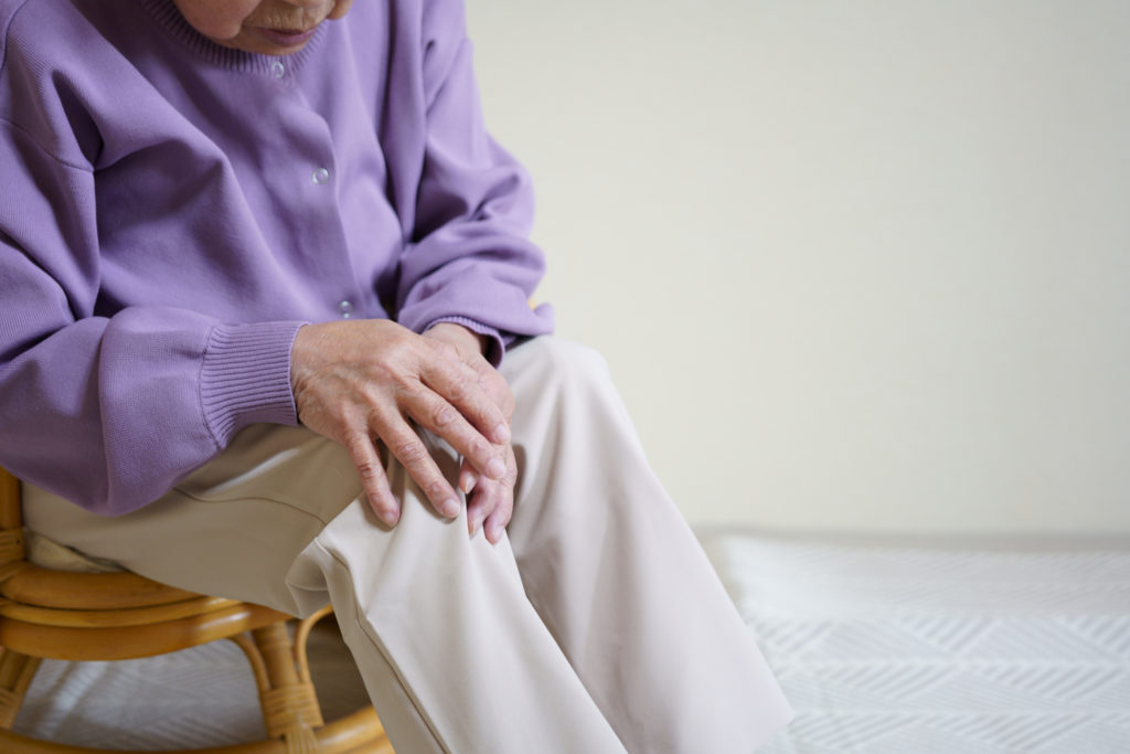イメージ画像：痛そうに膝をさする高齢女性